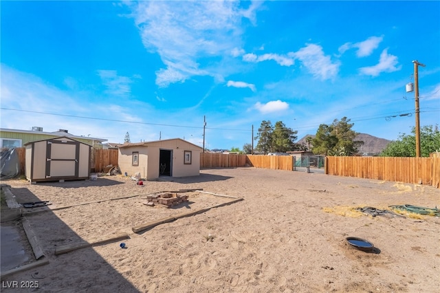 343 Tungsten St, Henderson, NV 89015 - view of yard with a fenced backyard, an outdoor structure, a fire pit, and a shed