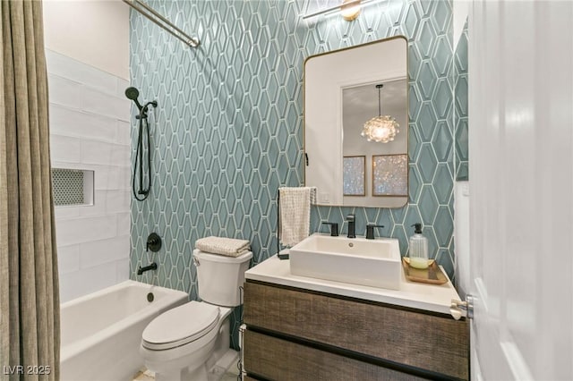 bathroom featuring vanity, shower / bath combo with shower curtain, toilet, and a notable chandelier