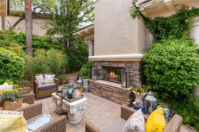 view of patio with an outdoor living space with a fireplace