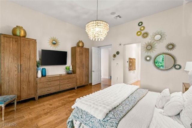 bedroom featuring a chandelier, visible vents, and light wood-style floors