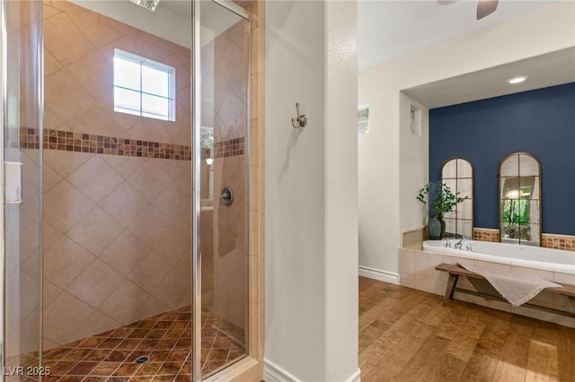 bathroom with wood finished floors, baseboards, and a stall shower