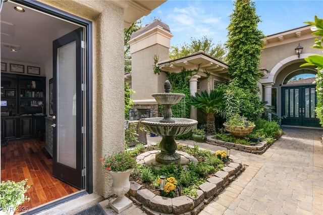 view of exterior entry with french doors and stucco siding