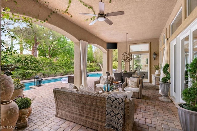 view of patio with a ceiling fan, an outdoor living space, and an outdoor pool