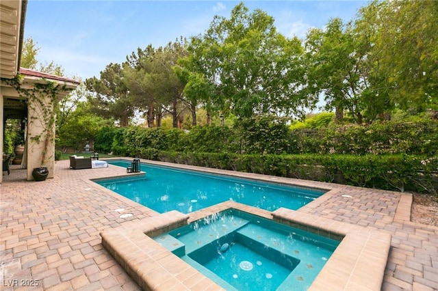 view of pool with a pool with connected hot tub and a patio area