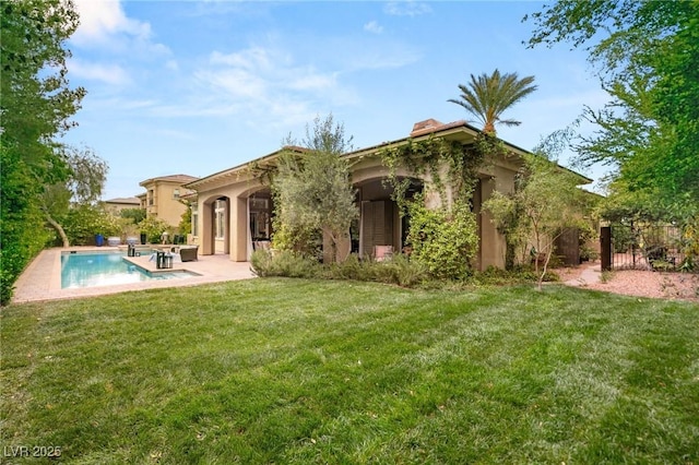 rear view of property with a patio, an outdoor pool, stucco siding, a chimney, and a yard