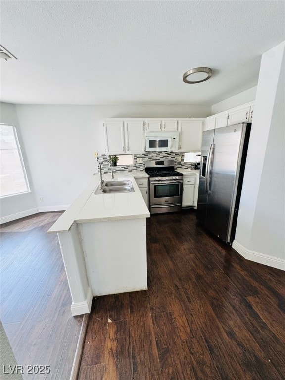 5711 Roundrock Dr, Las Vegas, NV 89142 - kitchen featuring a sink, light countertops, stainless steel appliances, baseboards, and dark wood-style floors
