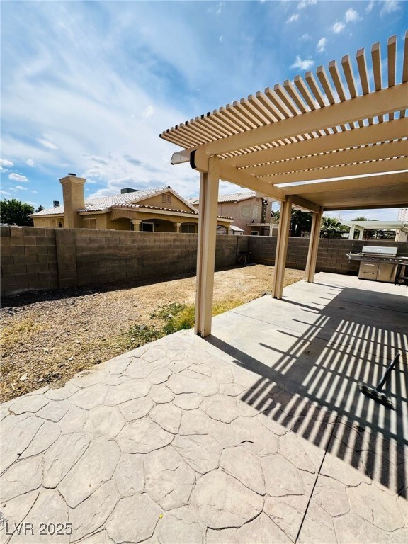 5711 Roundrock Dr, Las Vegas, NV 89142 - view of patio with a pergola, a fenced backyard, and a grill