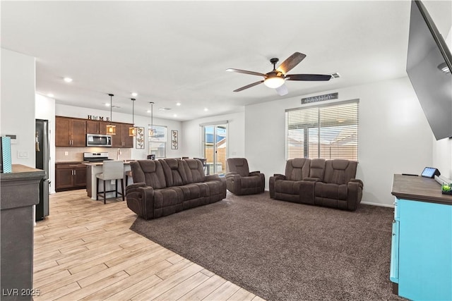 living area with ceiling fan, light wood finished floors, and recessed lighting