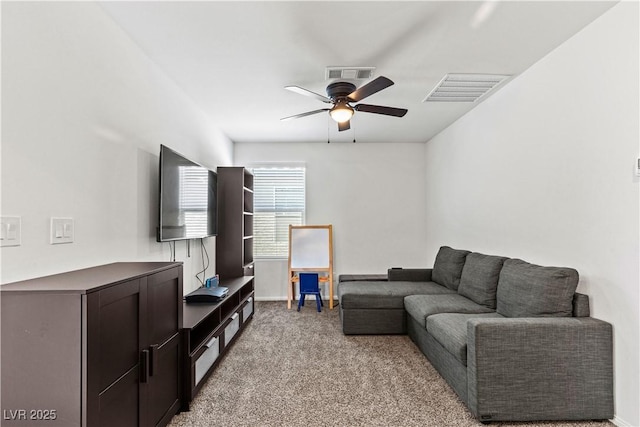 living room featuring a ceiling fan, light colored carpet, and baseboards