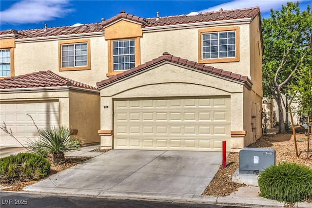 view of front of property featuring a garage, driveway, and a tile roof