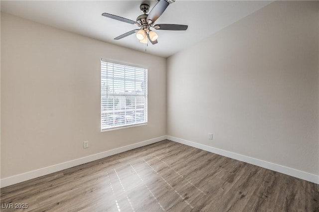 empty room featuring a ceiling fan, baseboards, and wood finished floors