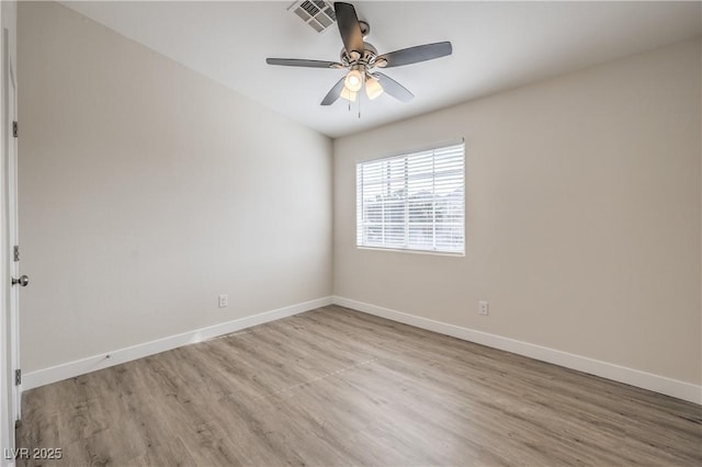 empty room featuring a ceiling fan, baseboards, visible vents, and wood finished floors
