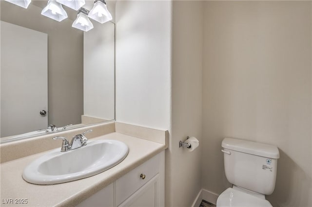 bathroom with toilet, baseboards, and vanity
