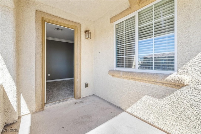 doorway to property featuring visible vents and stucco siding