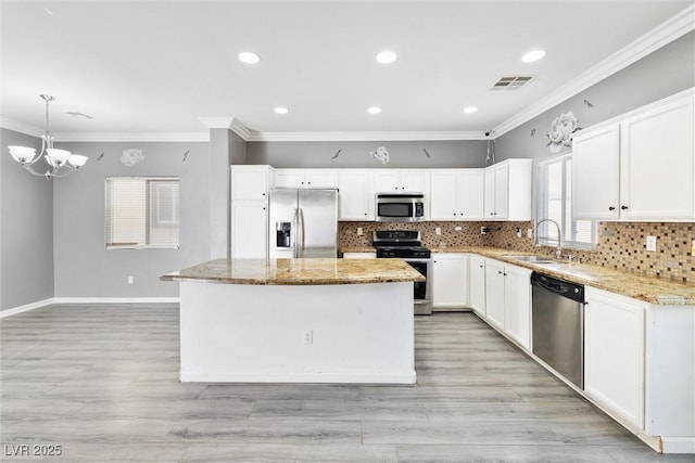 kitchen featuring crown molding, decorative backsplash, light stone countertops, a sink, and appliances with stainless steel finishes