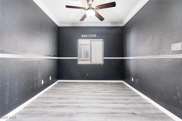 empty room with crown molding, a ceiling fan, baseboards, and wood finished floors