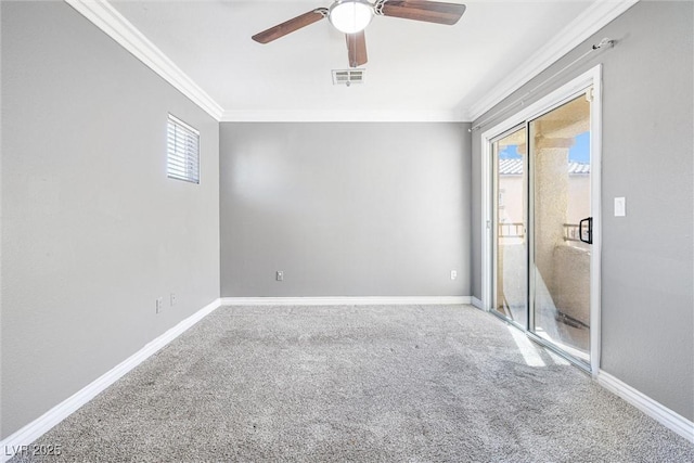 empty room featuring a ceiling fan, visible vents, crown molding, baseboards, and carpet