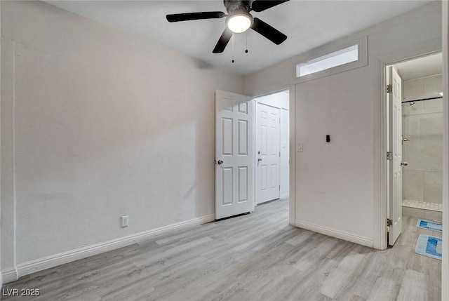 unfurnished bedroom with light wood-style floors, baseboards, a ceiling fan, and ensuite bath
