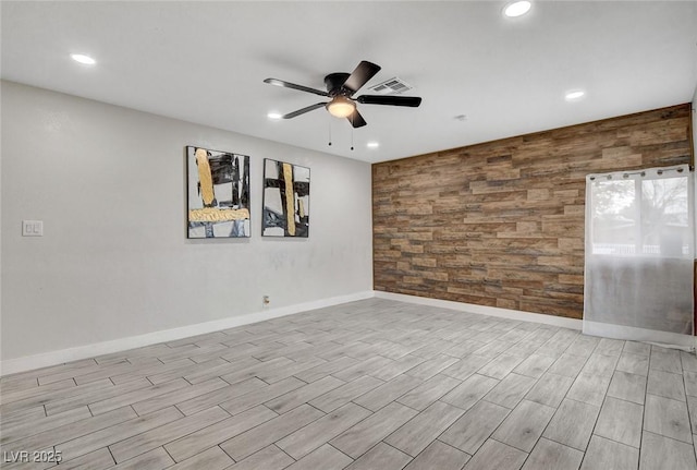 empty room featuring recessed lighting, ceiling fan, an accent wall, and wooden walls
