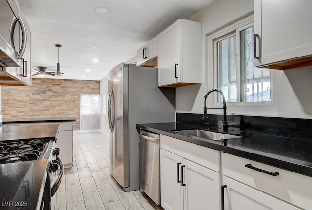 kitchen featuring ceiling fan, a sink, white cabinets, stainless steel appliances, and recessed lighting