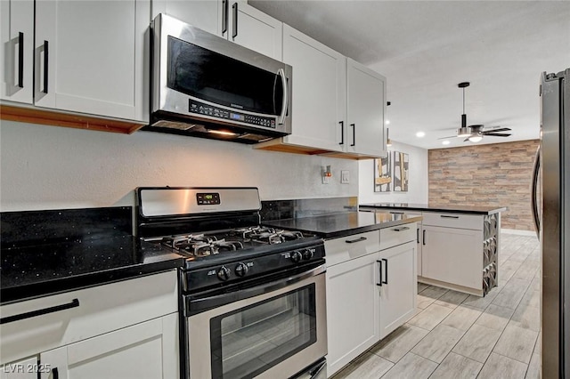 kitchen with stainless steel appliances, a ceiling fan, recessed lighting, white cabinetry, and a peninsula