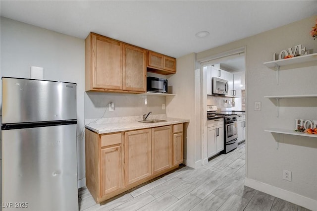 kitchen featuring baseboards, open shelves, a sink, and stainless steel appliances
