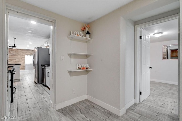 corridor with baseboards, wood tiled floor, and recessed lighting