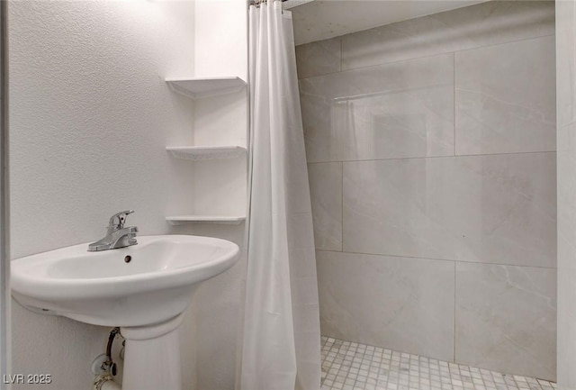 bathroom featuring a sink and tiled shower