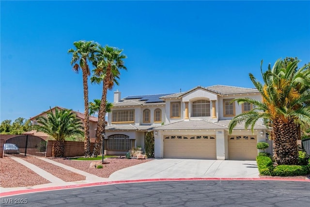 mediterranean / spanish-style house with an attached garage, roof mounted solar panels, stucco siding, and concrete driveway