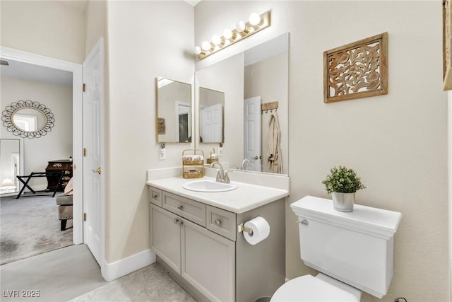 bathroom with vanity, baseboards, and toilet