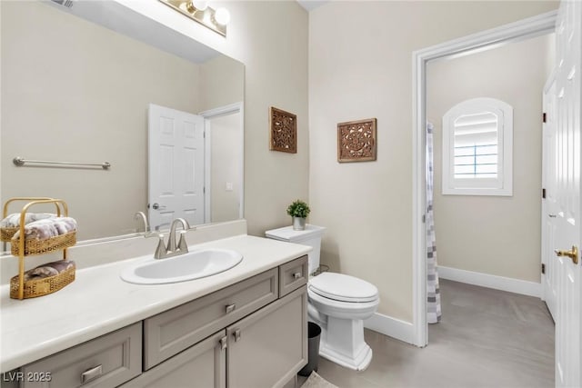 bathroom with toilet, baseboards, and vanity