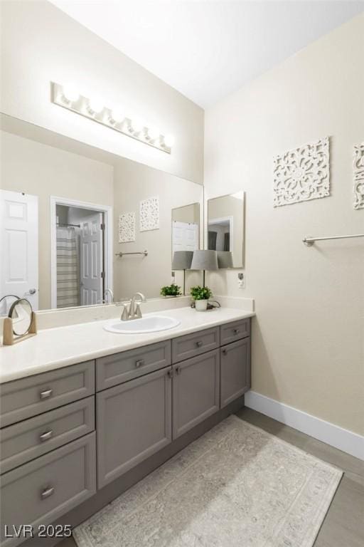 full bath featuring baseboards and vanity