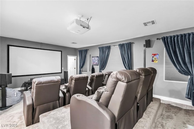 carpeted cinema room featuring visible vents and baseboards