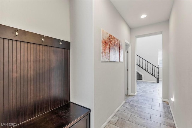 corridor with stairway, baseboards, light tile patterned floors, and recessed lighting