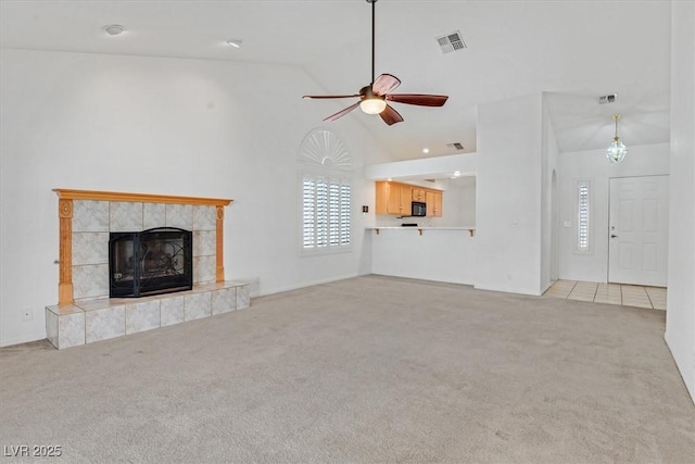 880 Autumn Canyon Way, Henderson, NV 89002 - unfurnished living room with visible vents, carpet floors, high vaulted ceiling, a tiled fireplace, and a ceiling fan