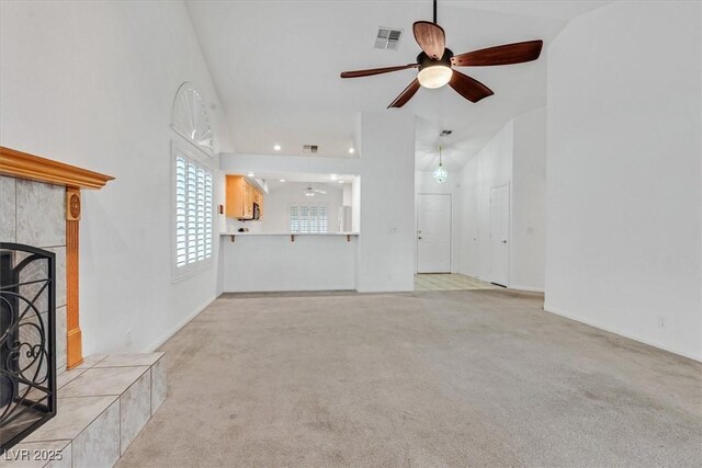 880 Autumn Canyon Way, Henderson, NV 89002 - unfurnished living room with ceiling fan, a tile fireplace, light carpet, a towering ceiling, and visible vents