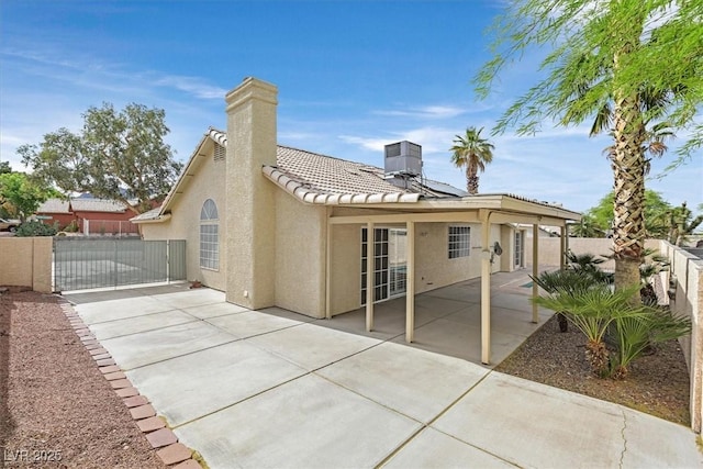 880 Autumn Canyon Way, Henderson, NV 89002 - back of house featuring fence private yard, stucco siding, a chimney, a gate, and solar panels