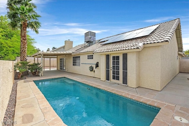880 Autumn Canyon Way, Henderson, NV 89002 - back of house with a tiled roof, a patio area, a fenced in pool, roof mounted solar panels, and stucco siding