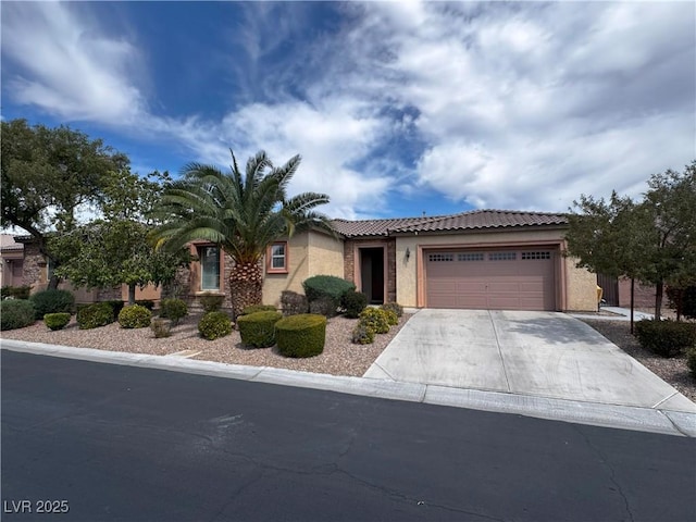 view of front of house featuring a garage, stucco siding, concrete driveway, and a tile roof