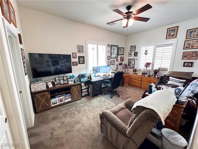 office space featuring carpet, a ceiling fan, and visible vents