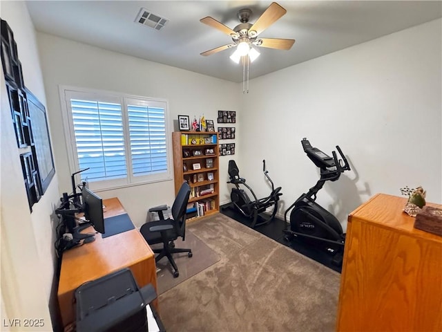 carpeted home office featuring a ceiling fan and visible vents