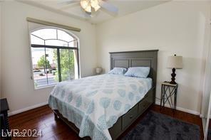 bedroom with baseboards, a ceiling fan, and dark wood finished floors