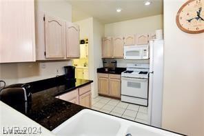 kitchen with dark countertops, white appliances, recessed lighting, a peninsula, and light tile patterned floors
