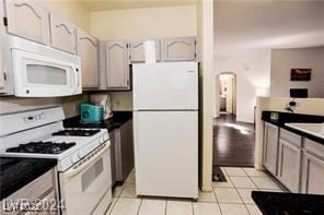 kitchen featuring light tile patterned floors and white appliances