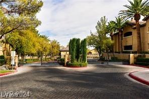 view of street with a gated entry and curbs
