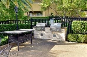 view of patio featuring area for grilling, exterior kitchen, and fence