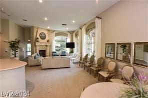 living room featuring recessed lighting, light colored carpet, and a fireplace