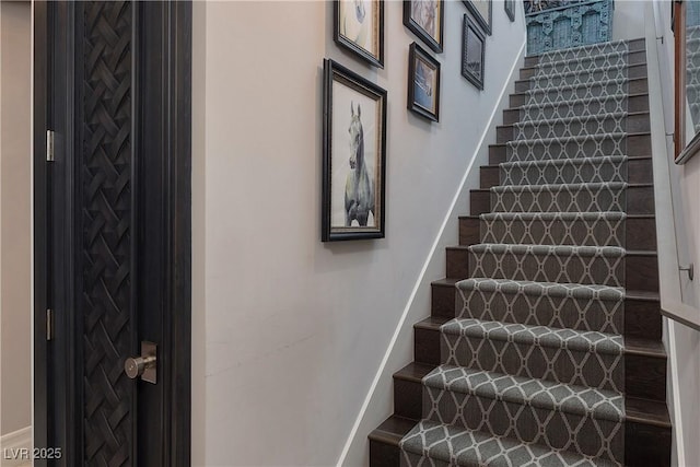 staircase featuring baseboards
