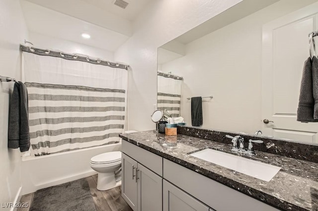 full bath with vanity, shower / tub combo with curtain, toilet, and visible vents