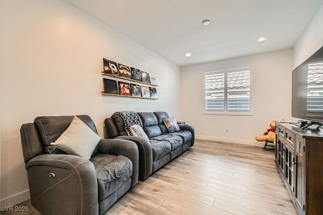 living room featuring recessed lighting, baseboards, and light wood finished floors